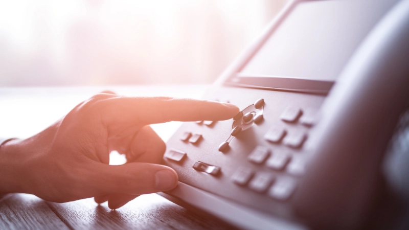 A man is pressing the keypad of the remote control.